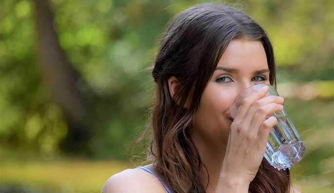 femme qui boit un verre d'eau